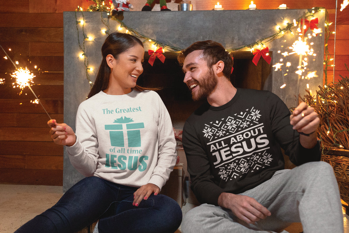 Couple wearing Christmas Jesus Sweatshirts holding sparklers